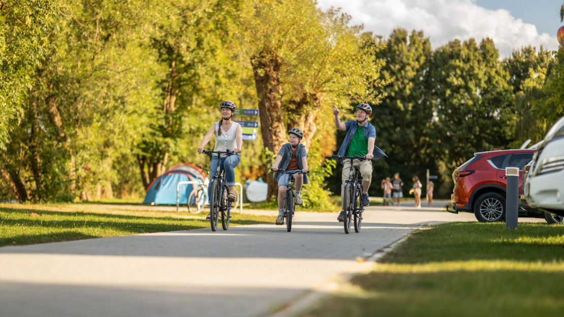 Mutter, Kind und Vater starten auf dem Campingplatz Kassel zu einer Fahrradtour.
