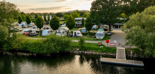 Luftaufnahme des Campingplatzes Kassel direkt an der Fulda mit Wohnmobilstellplatz im Hintergrund