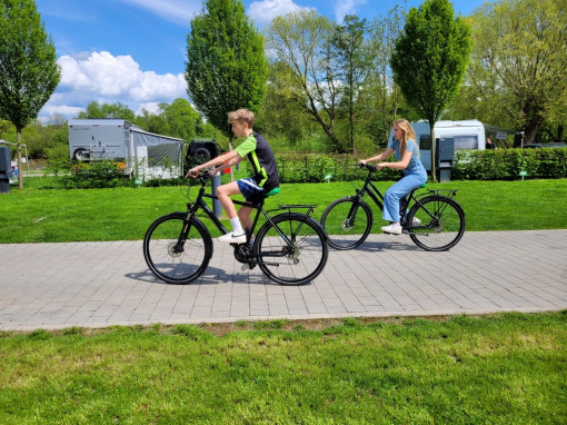 Two children ride bicycles from the bike rental at the Kassel campsite