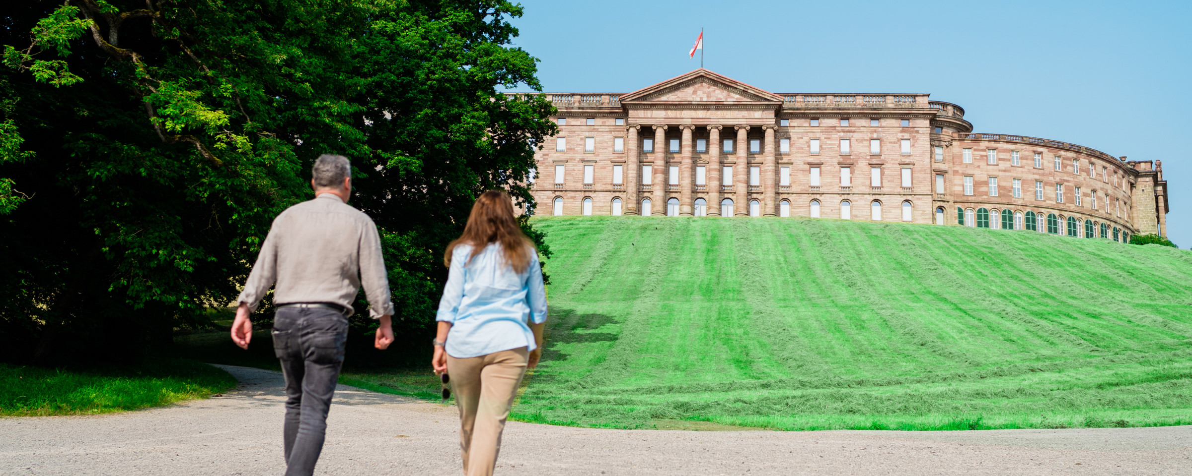 A couple walks towards Wilhelmshöhe Palace in the UNESCO World Heritage Site